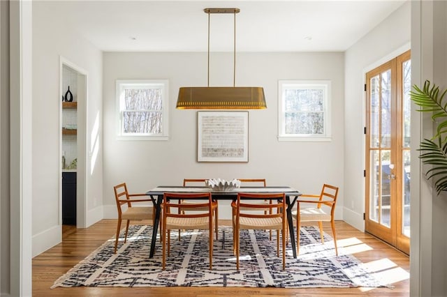 dining area with wood-type flooring and french doors