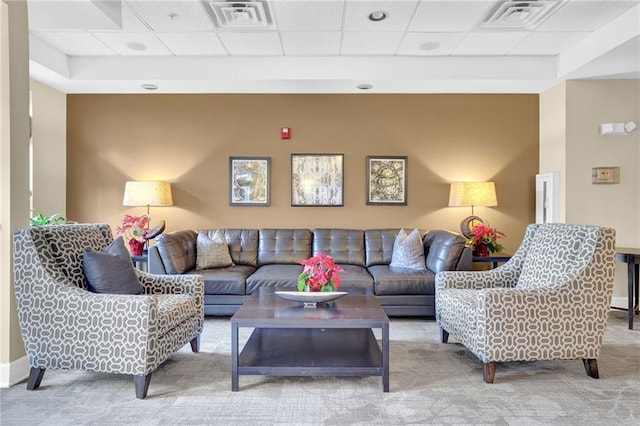 carpeted living room featuring a paneled ceiling