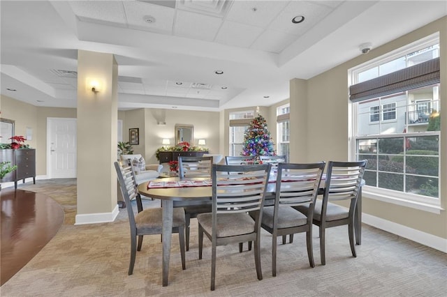 carpeted dining space featuring a tray ceiling and a paneled ceiling