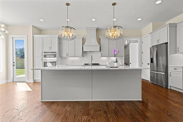 kitchen featuring sink, stainless steel dishwasher, gray cabinets, and a center island with sink