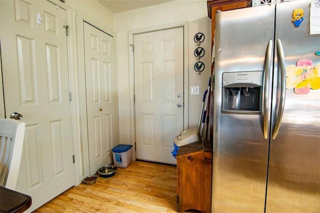 kitchen featuring light wood-style flooring and stainless steel refrigerator with ice dispenser