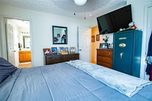 bedroom featuring a textured ceiling and ensuite bath