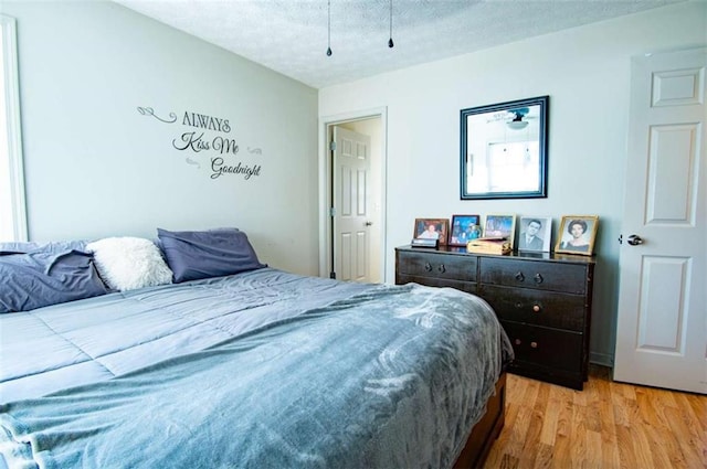 bedroom featuring light wood-style floors and a textured ceiling