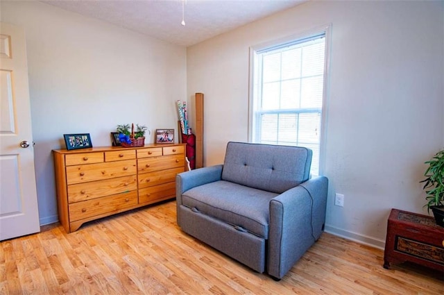 living area with light wood-style flooring and baseboards