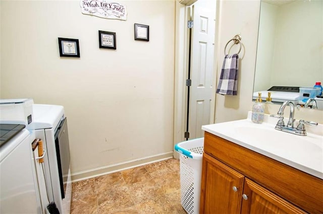 bathroom featuring washer and dryer, vanity, and baseboards