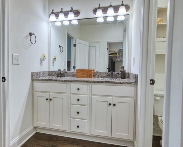 594 Maner Rd, Rockmart, GA 30153 - bathroom featuring double vanity, toilet, wood finished floors, a walk in closet, and baseboards