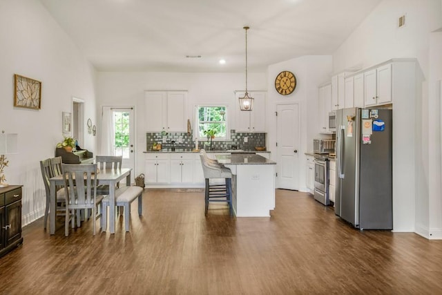 594 Maner Rd, Rockmart, GA 30153 - kitchen featuring appliances with stainless steel finishes, a breakfast bar area, white cabinetry, tasteful backsplash, and a center island