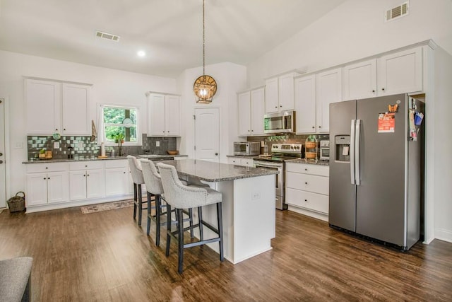 594 Maner Rd, Rockmart, GA 30153 - kitchen with stainless steel appliances, white cabinetry, backsplash, and a kitchen bar