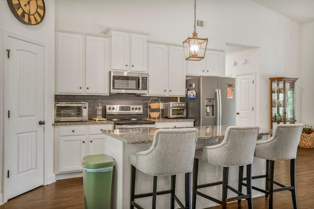 594 Maner Rd, Rockmart, GA 30153 - kitchen with appliances with stainless steel finishes, tasteful backsplash, white cabinets, a center island, and a high ceiling