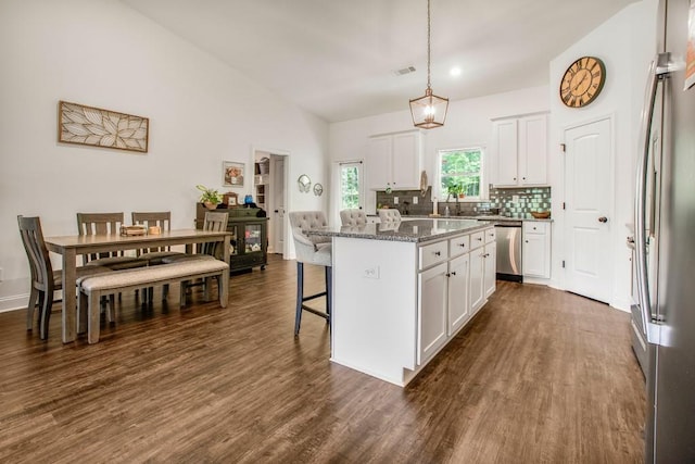 594 Maner Rd, Rockmart, GA 30153 - kitchen featuring stainless steel appliances, a center island, a kitchen breakfast bar, white cabinets, and decorative backsplash