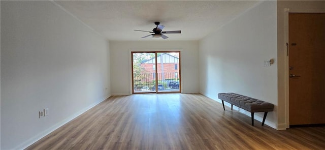 unfurnished room featuring wood finished floors, a ceiling fan, and baseboards