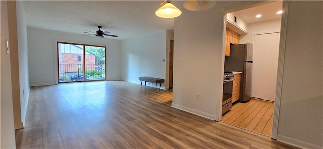 empty room with light wood-type flooring, a ceiling fan, baseboards, and recessed lighting