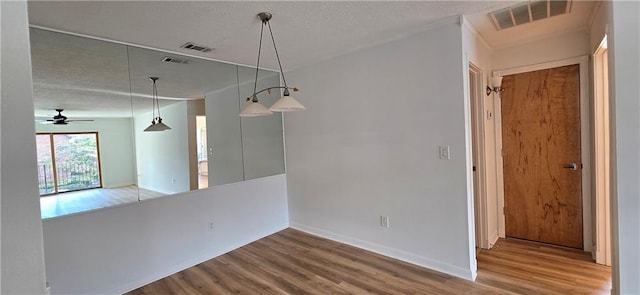 unfurnished dining area with wood finished floors, baseboards, and ceiling fan