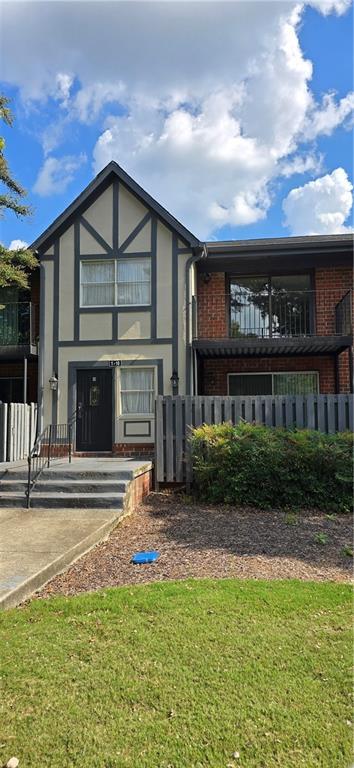 rear view of property with brick siding and a lawn