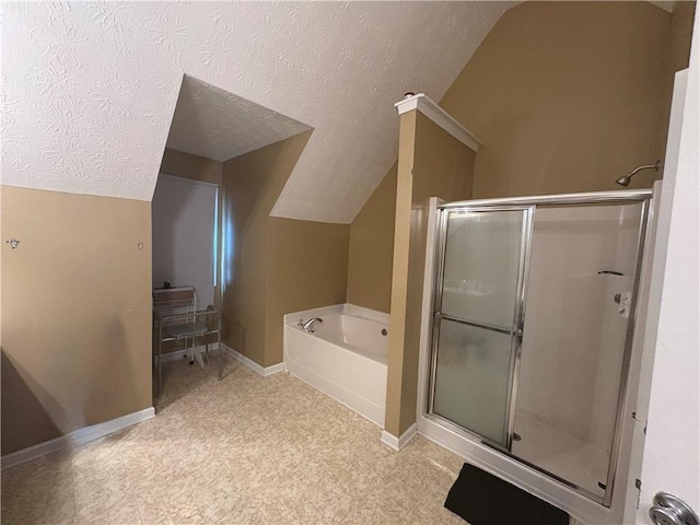 bathroom featuring a stall shower, vaulted ceiling, a textured ceiling, baseboards, and a bath