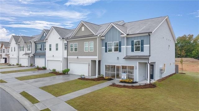 view of property with an attached garage, concrete driveway, a residential view, a front lawn, and board and batten siding