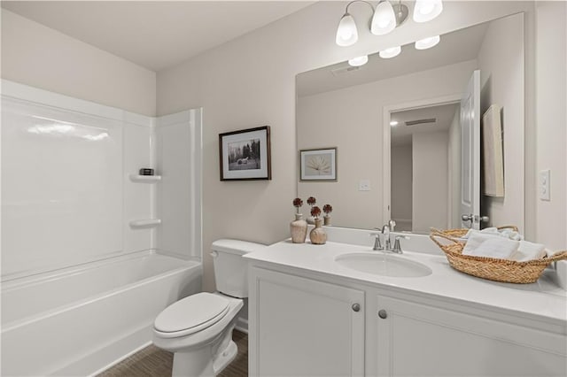 full bath featuring visible vents, shower / bathing tub combination, toilet, vanity, and wood finished floors