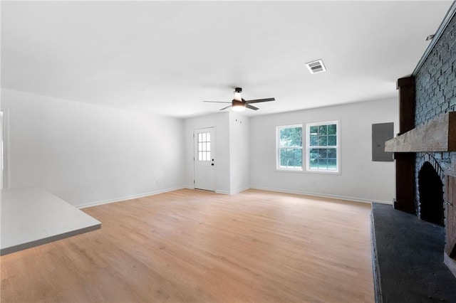 44 Crayton St, Rockmart, GA 30153 - unfurnished living room featuring a ceiling fan, a fireplace, light wood-style floors, and electric panel