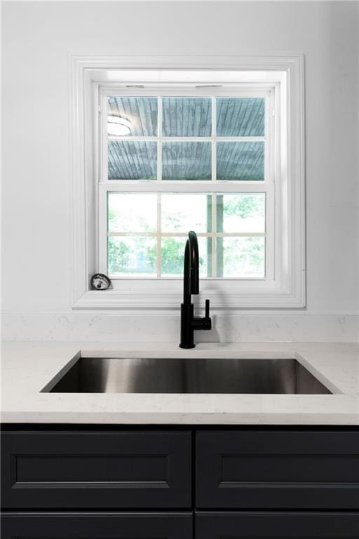 44 Crayton St, Rockmart, GA 30153 - kitchen view of a sink, light stone countertops, dark cabinets, and gray cabinetry