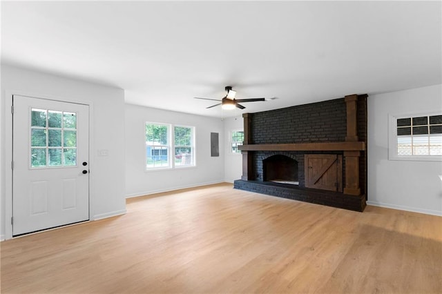 44 Crayton St, Rockmart, GA 30153 - unfurnished living room featuring ceiling fan, light wood-style floors, a brick fireplace, baseboards, and electric panel