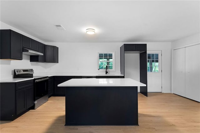 44 Crayton St, Rockmart, GA 30153 - kitchen with stainless steel range with electric cooktop, under cabinet range hood, a center island, light wood-style flooring, and a sink