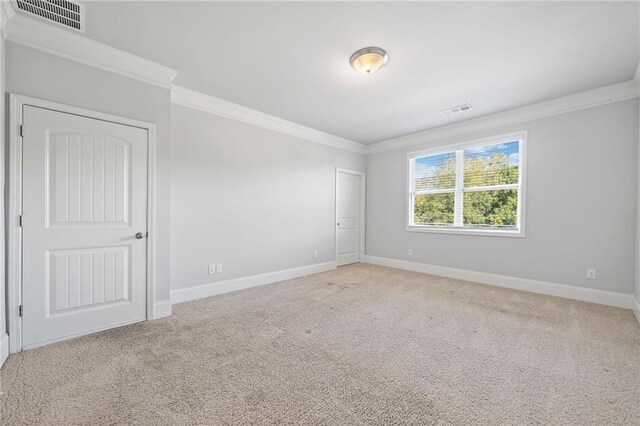 spare room featuring light carpet and ornamental molding