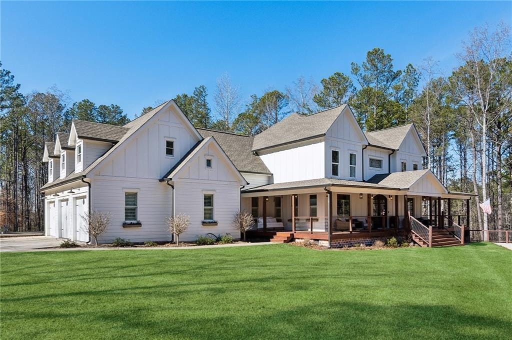 back of property with a porch, a garage, and a yard