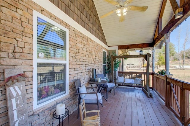 wooden terrace featuring covered porch and ceiling fan