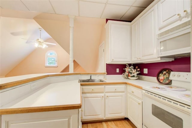 kitchen with white appliances, white cabinets, light countertops, and a sink