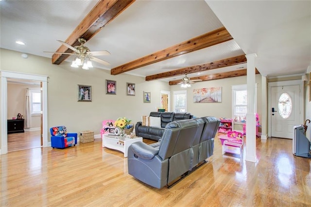 living room with beam ceiling, light wood-style floors, and a wealth of natural light