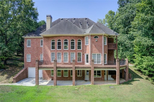 rear view of property featuring a patio area, a lawn, and brick siding