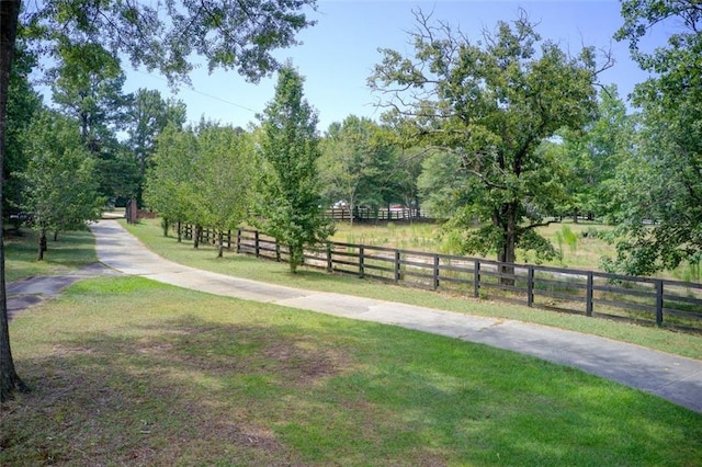 surrounding community featuring a lawn, concrete driveway, and fence