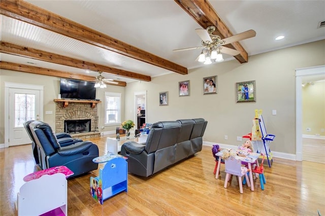 living room with beam ceiling, light wood-type flooring, and baseboards