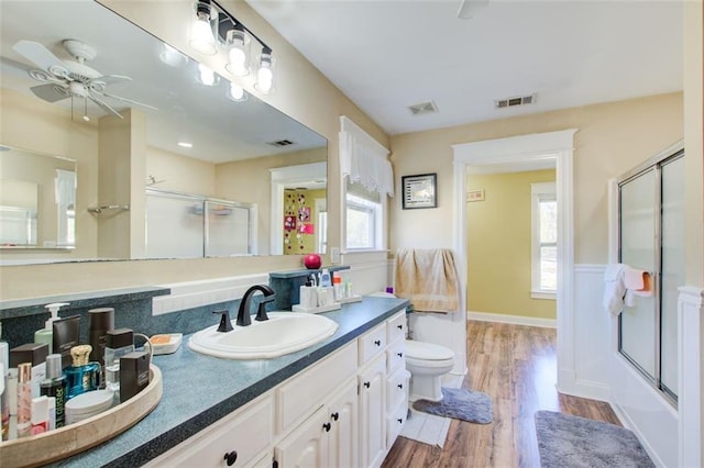 bathroom featuring visible vents, wood finished floors, and a shower with shower door