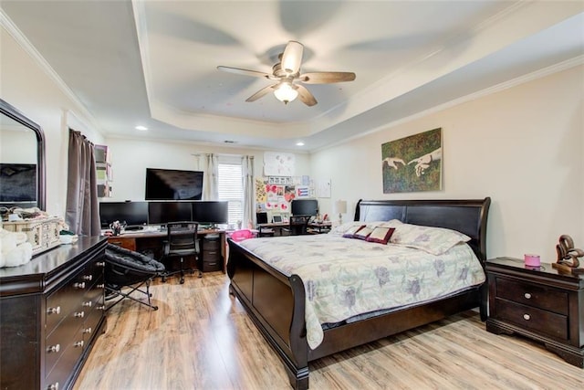 bedroom with light wood-style flooring, a raised ceiling, ceiling fan, and ornamental molding