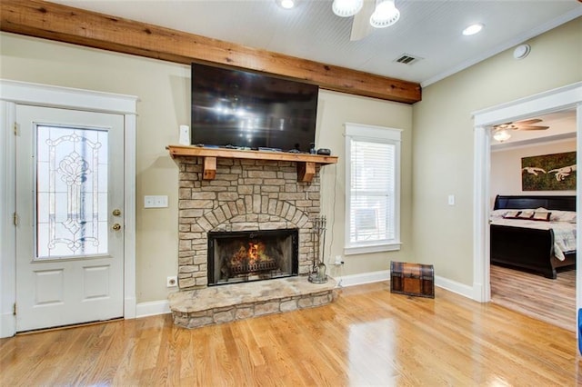 unfurnished living room with visible vents, a ceiling fan, wood finished floors, and a fireplace