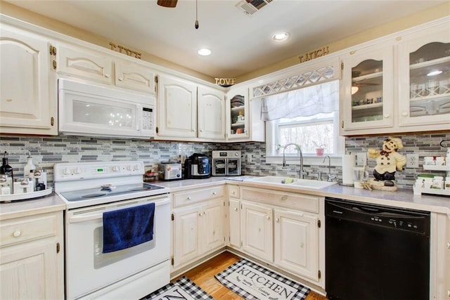 kitchen with visible vents, white appliances, light countertops, and a sink