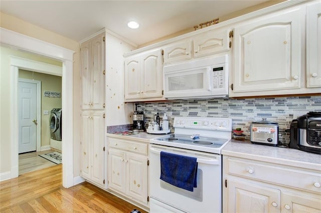 kitchen with backsplash, light countertops, light wood-type flooring, washer and dryer, and white appliances