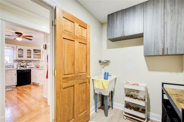 kitchen with baseboards, dishwasher, light countertops, light wood-style flooring, and a ceiling fan