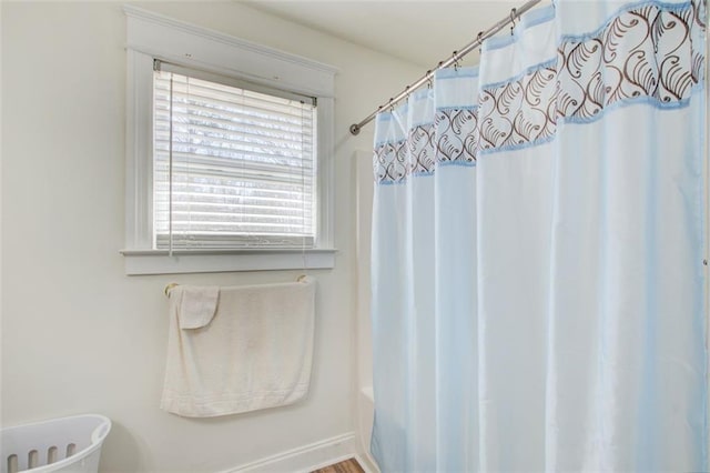 bathroom with a washtub and a shower with shower curtain