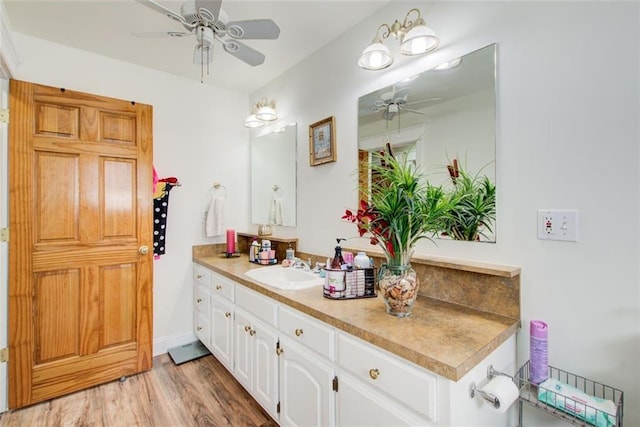 bathroom with baseboards, vanity, a ceiling fan, and wood finished floors