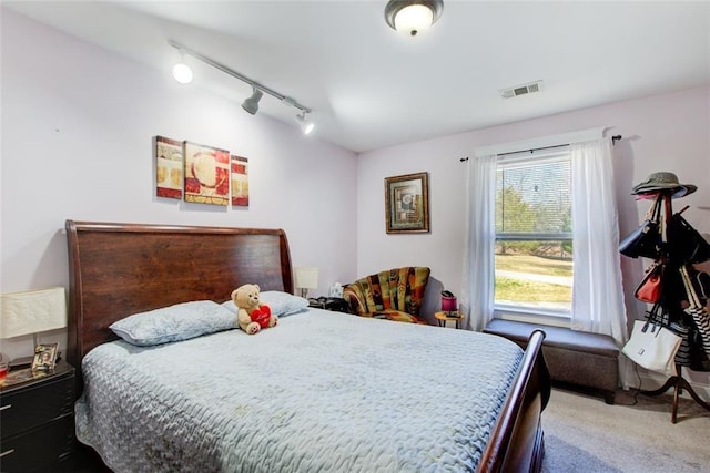 bedroom with visible vents, track lighting, and carpet flooring