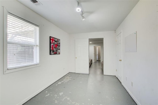 spare room featuring visible vents, finished concrete flooring, and baseboards