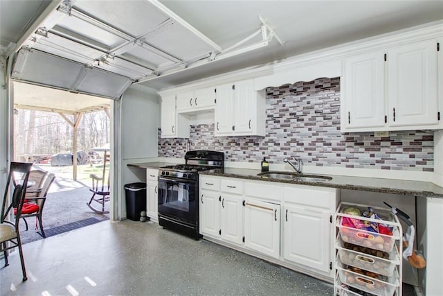 kitchen with backsplash, white cabinets, gas stove, and a sink