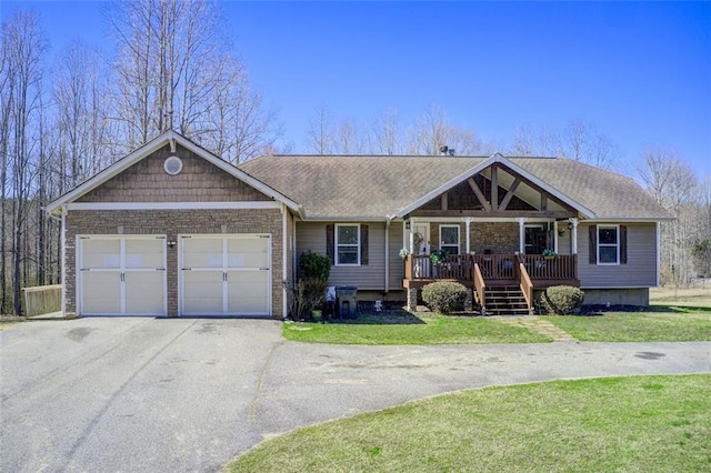 view of front of house with aphalt driveway, a porch, and a front yard