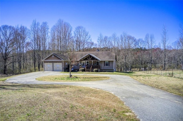 view of front of home featuring aphalt driveway, an attached garage, and a front lawn