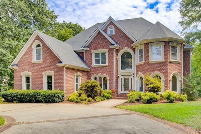 view of front facade featuring brick siding and a front yard