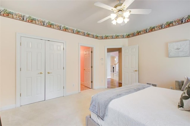 bedroom with baseboards, visible vents, a closet, and light carpet