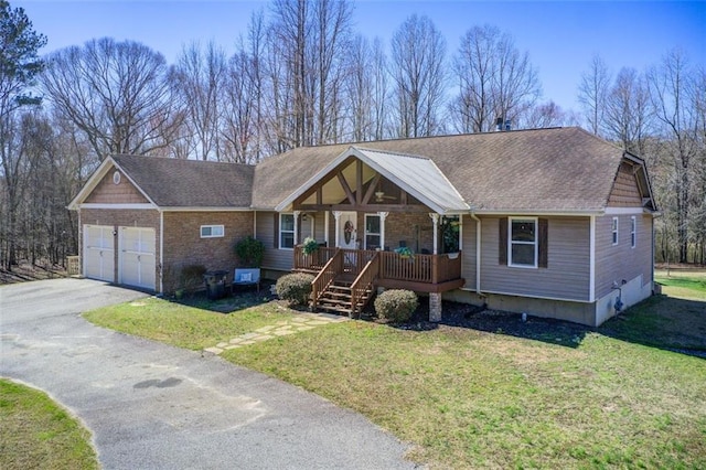 view of front of property featuring a shingled roof, a front lawn, aphalt driveway, a porch, and a garage