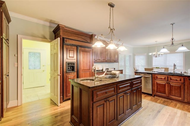 kitchen featuring a sink, light wood-style floors, dishwasher, and a center island with sink